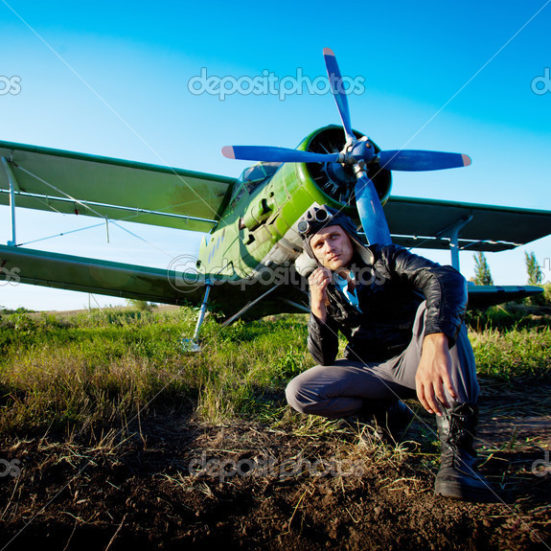 Pilot is sitting in front of vintage plane Kevon Morin- Corporate Aircraft Sales & Acquisition